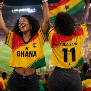 May include: A cropped V-neck jersey featuring the Ghana flag colors of red, yellow, and green. The front displays the word GHANA with a black star, while the back shows the text YOUR NAME and the number 11 in bold black lettering.