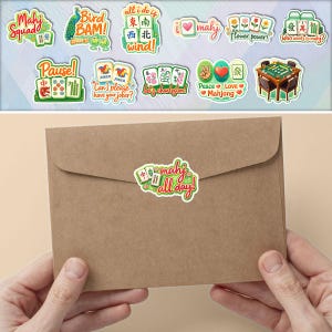 A pair of hands holding a brown envelope with a sticker on it, and a background featuring various stickers and illustrations related to mahjong.
