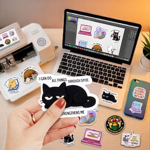 a person holding a sticker over a laptop