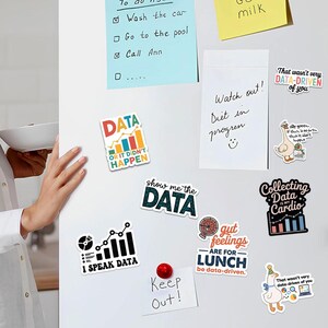 Puede incluir: Una colecci&oacute;n de coloridos imanes para nevera con juegos de palabras y gr&aacute;ficos relacionados con datos. Los imanes incluyen frases como &laquo;Mu&eacute;strame los datos&raquo; y &laquo;Datos o no sucedi&oacute;&raquo;. Un im&aacute;n rojo dice &laquo;Keep Out!&raquo;