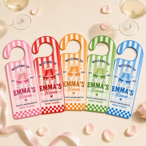 May include: Five vertical door hangers with striped patterns in pink, red, orange, green, and blue. Each features the text 'WELCOME TO EMMA'S Room', 'OCT 2027', 'OLIVIA'S BACHELORETTE MIAMI, FLORIDA', and a graphic of two clinking champagne glasses.