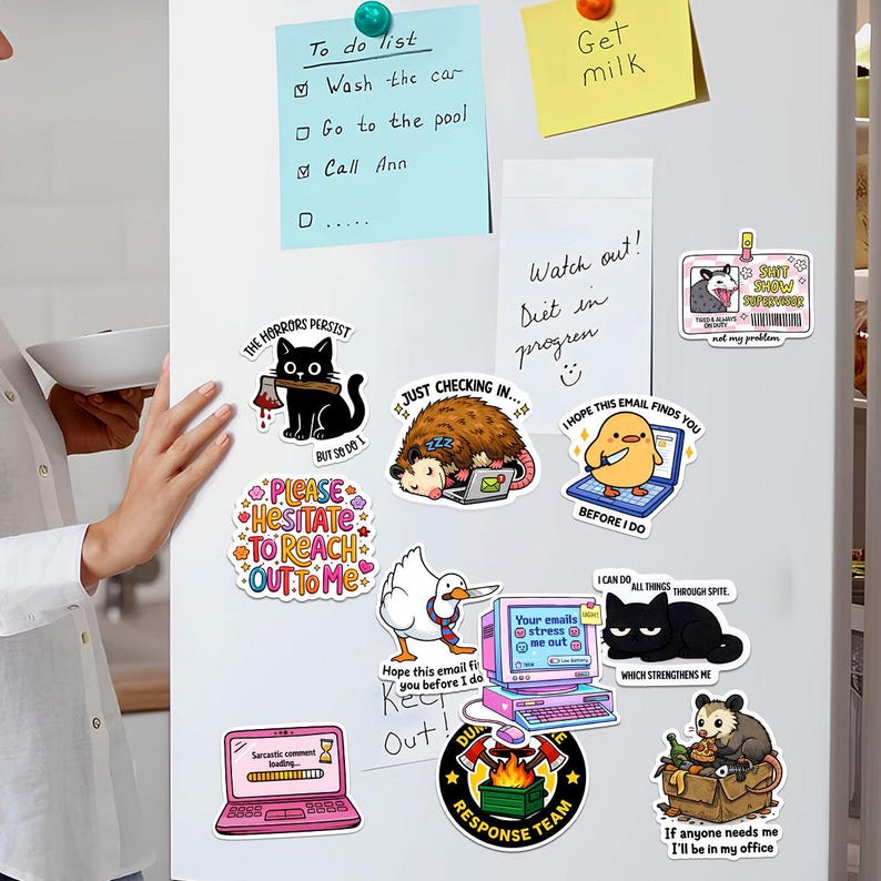 a refrigerator covered in various stickers, including a person's hand holding the refrigerator door, and a person's hand placing a note on the fridge.