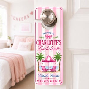 May include: A rectangular door hanger with a pink and white vertical striped background. It features the text "WELCOME TO CHARLOTTE'S Bachelorette", "Nashville, Tennessee", and "LEXI'S ROOM". The design includes a pink bow, palm trees, and beach chairs.