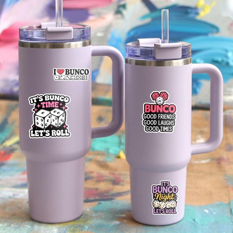 May include: Two lavender insulated tumblers with handles and straws. Each tumbler has stickers with the text "I ❤️ BUNCO", "It's Bunco Time, Let's Roll", "Bunco Good Friends Good Laughs Good Times", and "It's Bunco Night, Let's Roll".