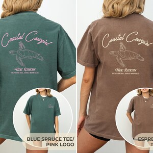 May include: Two oversized t-shirts with a sea turtle graphic and the text "Coastal Cowgirl" in pink on a blue spruce tee and tan on an espresso tee. The text "Tide Riders" is below the graphic with the text "Saltwater Soul, Saddle Worn Sole" underneath.