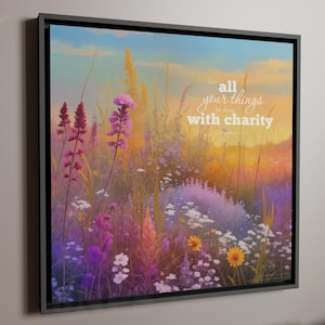 May include: A framed canvas art print featuring a vibrant field of wildflowers in shades of purple, pink, yellow, and white. The artwork includes the text "Let all your things be done with charity" in a script font, set against a sunset sky.
