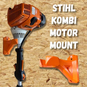 May include: An orange and black STIHL Kombi motor with a matching orange mount. The motor has a black handle and a white base. The text "STIHL KOMBI MOTOR MOUNT" is displayed in white.