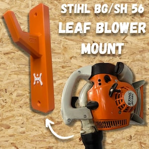 May include: An orange leaf blower mount with the text "STIHL BG/SH 56 LEAF BLOWER MOUNT" next to an orange and white leaf blower. The mount is designed to hold the leaf blower.