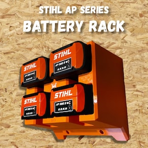 Puede incluir: Estante naranja para baterías de la serie STIHL AP. El estante muestra el texto "STIHL AP SERIES BATTERY RACK". Tiene capacidad para cuatro baterías, cada una con el logotipo de STIHL y la información del modelo.