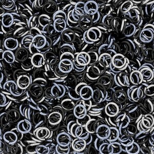 Puede incluir: Una imagen de primer plano de un mont&oacute;n de anillos de salto plateados y negros. Los anillos de salto son peque&ntilde;os y redondos, y son perfectos para la elaboraci&oacute;n de joyas.