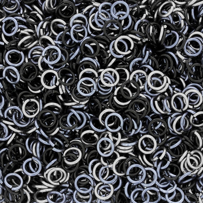 Puede incluir: Una imagen de primer plano de un mont&oacute;n de anillos de salto plateados y negros. Los anillos de salto son peque&ntilde;os y redondos, y son perfectos para la elaboraci&oacute;n de joyas.