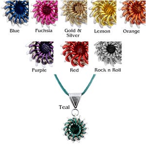 May include: A teal cord necklace with a silver and teal metal pendant in the shape of a flower. The pendant is available in 10 different colors: blue, fuchsia, gold & silver, lemon, orange, purple, red, rock n roll, and teal.