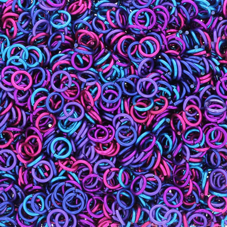 Puede incluir: Una imagen de primer plano de una gran cantidad de peque&ntilde;os anillos de salto met&aacute;licos. Los anillos son una mezcla de colores p&uacute;rpura y azul.