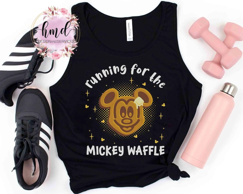 May include: Black tank top with the text "running for the MICKEY WAFFLE" and a Mickey Mouse waffle graphic. The image includes black sneakers, pink dumbbells, and a pink water bottle.