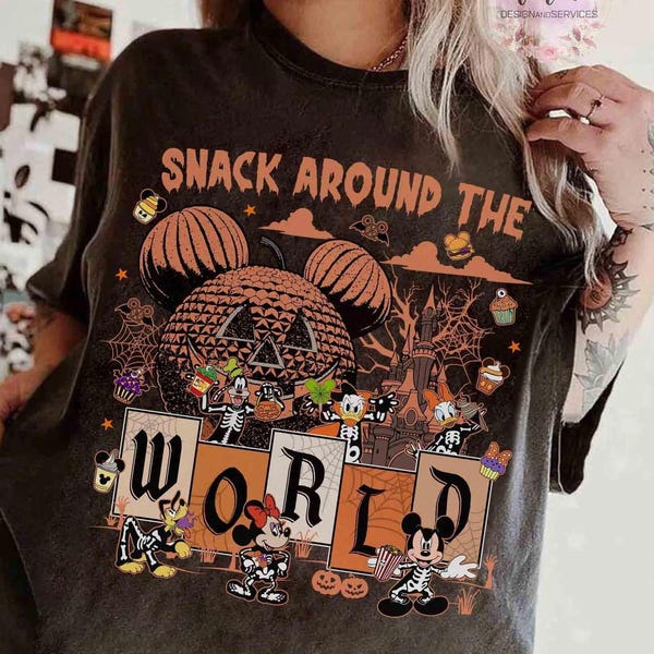 May include: Dark gray t-shirt with a Halloween-themed graphic. The design features pumpkins, cartoon characters, and the text "SNACK AROUND THE WORLD". The shirt has a distressed look.