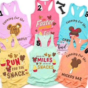 May include: A collection of six colorful racerback tank tops with fun graphics and text. Designs include Mickey Mouse-themed treats and phrases like "Running for the Waffle" and "Run for the Snack."