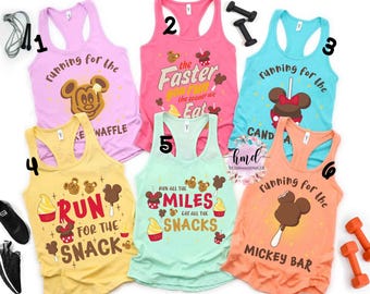Könnte beinhalten: Sechs farbenfrohe Racerback-Tops mit lustigen Grafiken und Texten. Designs beinhalten Mickey Mouse-Motive und Sätze wie "Running for the Waffle" und "Run for the Snack."