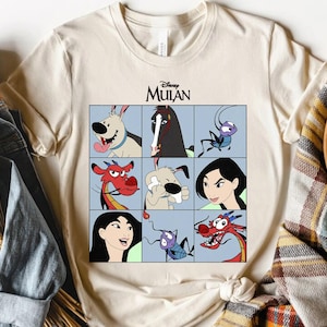 Może przedstawiać: Kremowa koszulka z siatką postaci z filmu Disneya Mulan. Projekt zawiera smoka Mushu, Mulan, Cri-Kee i konia Khana. Logo Disneya Mulan jest wydrukowane u góry.