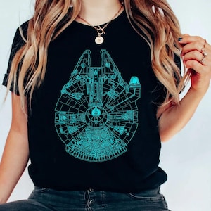 May include: Black t-shirt featuring a detailed teal blueprint design of the Millennium Falcon. The graphic covers the front of the shirt, showcasing the iconic spaceship's intricate details. The shirt is a classic crew neck style.