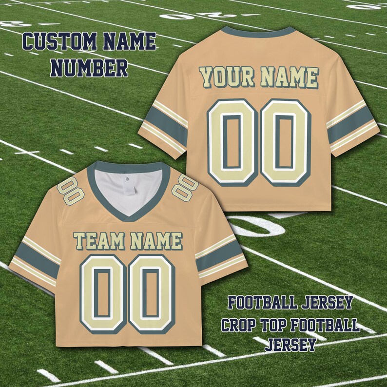 Puede incluir: Camiseta de f&uacute;tbol corta de color beige con detalles en azul y blanco. La camiseta presenta el texto "TEAM NAME" y "YOUR NAME" con el n&uacute;mero "00". La imagen tambi&eacute;n incluye el texto "CUSTOM NAME NUMBER" y "FOOTBALL JERSEY CROP TOP FOOTBALL JERSEY".
