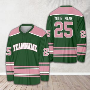 Pu&ograve; includere: Maglia da hockey verde e rosa con il numero 25 e il testo "YOUR NAME" sul davanti e il testo "TEAMNAME" sul davanti.