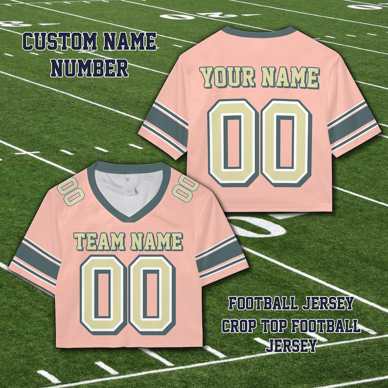 Puede incluir: Top corto de camiseta de f&uacute;tbol rosa con el texto "YOUR NAME" y "TEAM NAME" y el n&uacute;mero "00". La camiseta tiene detalles en verde azulado oscuro y beige claro y el texto "CUSTOM NAME NUMBER" y "FOOTBALL JERSEY CROP TOP FOOTBALL JERSEY".
