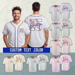 Puede incluir: Camiseta de béisbol a rayas blancas y azul marino con el número 15 y el nombre "Hunter" en la espalda. La parte delantera presenta un gráfico de béisbol y bate. La imagen también muestra diferentes opciones de color.