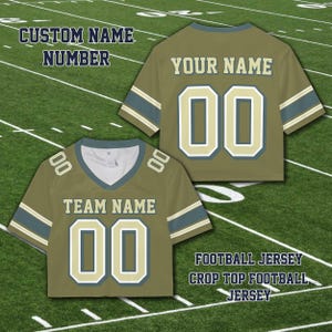 Puede incluir: Tops de camiseta de f&uacute;tbol verde oliva con detalles en blanco y dorado. Las camisetas presentan el texto "TEAM NAME" y "YOUR NAME" con el n&uacute;mero "00". La imagen tambi&eacute;n incluye el texto "CUSTOM NAME NUMBER" y "FOOTBALL JERSEY CROP TOP FOOTBALL JERSEY".