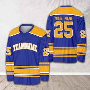Pu&ograve; includere: Una maglia da hockey blu e oro con il numero 25 e il testo "YOUR NAME" sul retro. La parte anteriore della maglia ha il testo "TEAMNAME" e il numero 25 sulle maniche.