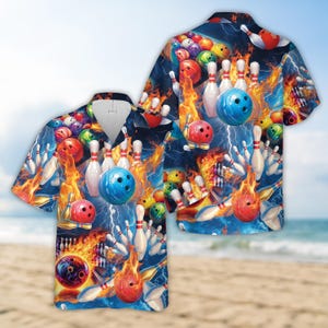 Puede incluir: Una camisa hawaiana azul y roja con un patrón de bolas de bolos y bolos. La camisa tiene un diseño brillante y colorido con llamas y rayos.