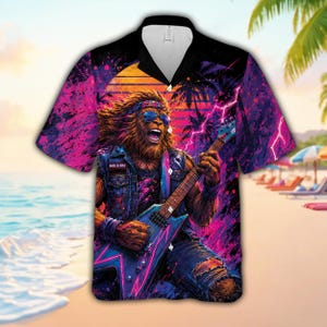 Puede incluir: Camisa de manga corta con un llamativo gráfico de un león tocando la guitarra eléctrica. El diseño incorpora un atardecer retro, palmeras y rayos en tonos rosas, morados y azules. La camisa tiene un cuello negro, sobre un fondo de escena de playa.