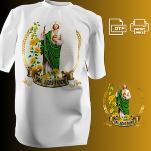 Puede incluir: Camiseta blanca con una imagen religiosa de San Judas Tadeo, rodeada de girasoles y una corona dorada. El diseño incluye el texto "SAN JUDAS TADEO" en una pancarta. También es visible una versión más pequeña del diseño.