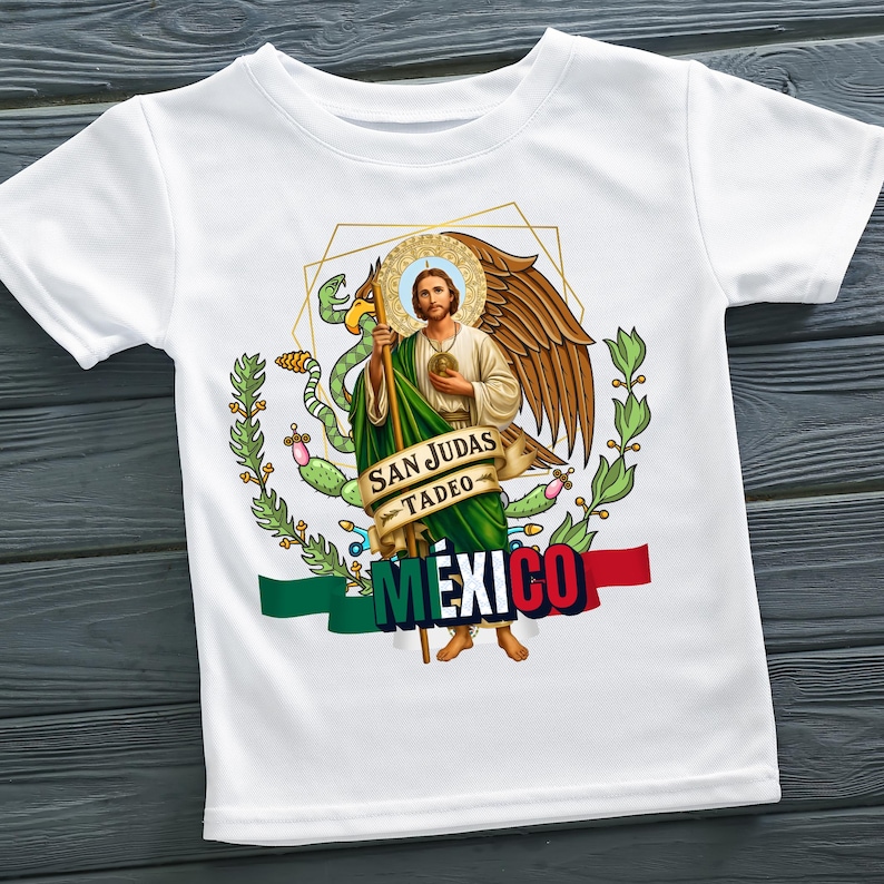 May include: White t-shirt featuring a graphic of San Judas Tadeo with a halo, wings, and a staff. The design includes the words "SAN JUDAS TADEO" and "MEXICO" with the Mexican flag colors.