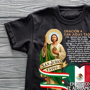 May include: Black t-shirt featuring an illustration of Saint Jude Thaddeus, holding a staff, with text in Spanish. The design includes the Mexican flag and the words "San Judas Tadeo" and "En Mexico Te Adoramos."