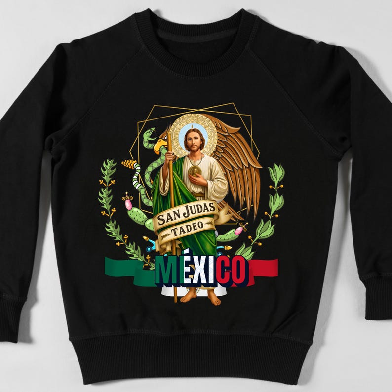 May include: Black sweatshirt featuring a graphic of San Judas Tadeo, a religious figure, with a halo, wings, and a staff. The design includes the text "SAN JUDAS TADEO" and "MEXICO" with the colors of the Mexican flag.