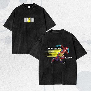 May include: Black t-shirt with the word "DISPATCH" in white and yellow on the front. The back of the shirt features a graphic of two figures running with the words "KEEP UP".