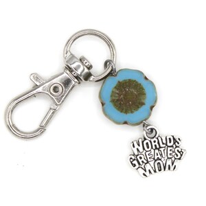 May include: Silver keyring with a blue and brown flower charm and a silver charm that says "World's Greatest Mom".