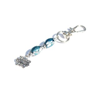 May include: A keychain with a silver clasp and ring. The keychain features three blue and white patterned beads and a charm that reads "World's Greatest Mom."