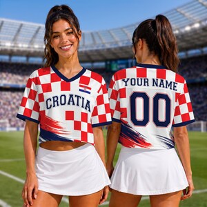 May include: A cropped V-neck jersey featuring a red and white checkered pattern, the text CROATIA on the front, and a small Croatian flag emblem. The back displays the text YOUR NAME above the number 00, with navy blue accents and brush strokes.