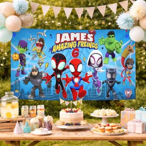 May include: A rectangular blue party banner featuring cartoon characters including Spider-Man, Hulk, and Black Panther with the text James and his Amazing Freinds 6. The banner is displayed above a table with a cake, treats, and gift boxes.
