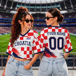 May include: A short-sleeved jersey featuring a red and white checkerboard pattern, the text "CROATIA" on the front, and "YOUR NAME" with the number "00" on the back. The design includes a small Croatian flag emblem and navy blue accents.