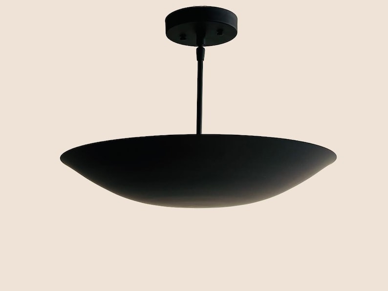 May include: A black pendant light fixture with a wide, shallow, saucer-shaped shade.