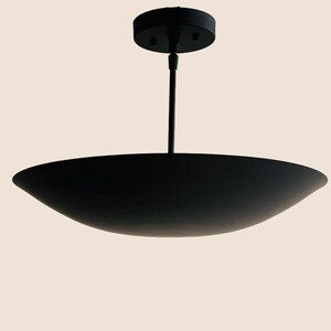 May include: A black pendant light fixture with a wide, shallow, saucer-shaped shade.