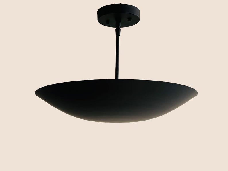 May include: A black pendant light fixture with a wide, shallow, saucer-shaped shade.