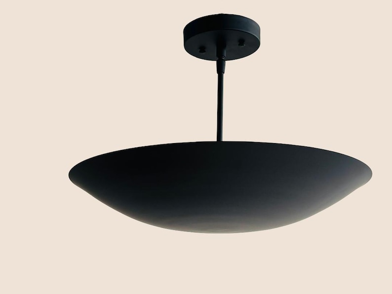 May include: A black pendant light fixture with a wide, shallow, saucer-shaped shade.