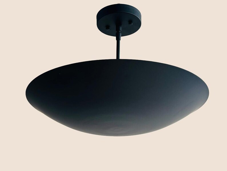 May include: A black metal ceiling light fixture with a wide, shallow, saucer-shaped shade.