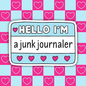 May include: A sticker with a light blue background and the text "HELLO I'M a junk journaler" in black. The sticker has a white border and is decorated with pink hearts. The background is a pattern of pink hearts on a blue and white checkered pattern.