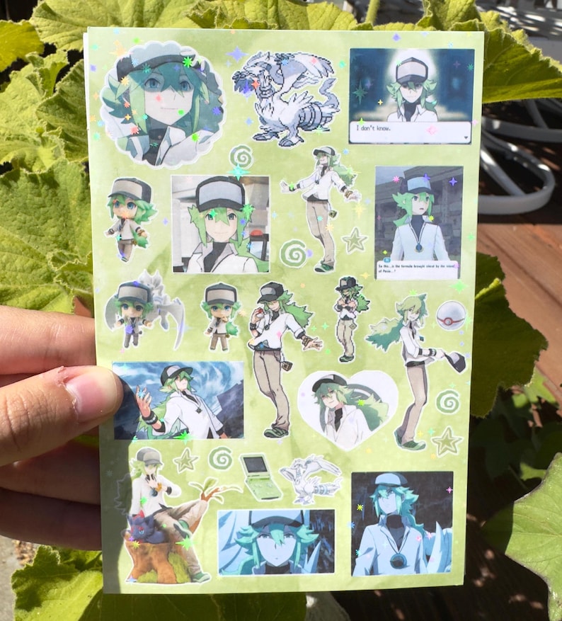 May include: A sheet of stickers featuring various images of a character with green hair and a white and black outfit. The stickers include images of the character in different poses, along with a white dragon and other decorative elements.