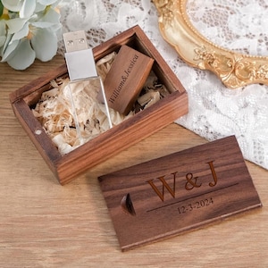 May include: A wooden USB drive and a wooden box with the engraved names "William & Jessica". The box contains shredded paper. A wooden card is engraved with "W & J" and the date "12-3-2024".