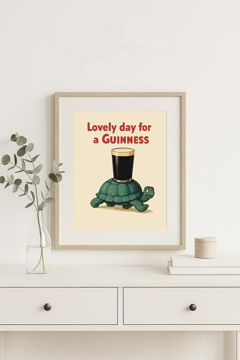 Puede incluir: Impresi&oacute;n enmarcada con una ilustraci&oacute;n de una tortuga verde con un vaso de Guinness. El texto "Lovely day for a Guinness" es rojo. La obra de arte tiene un estilo vintage, ideal para un bar.